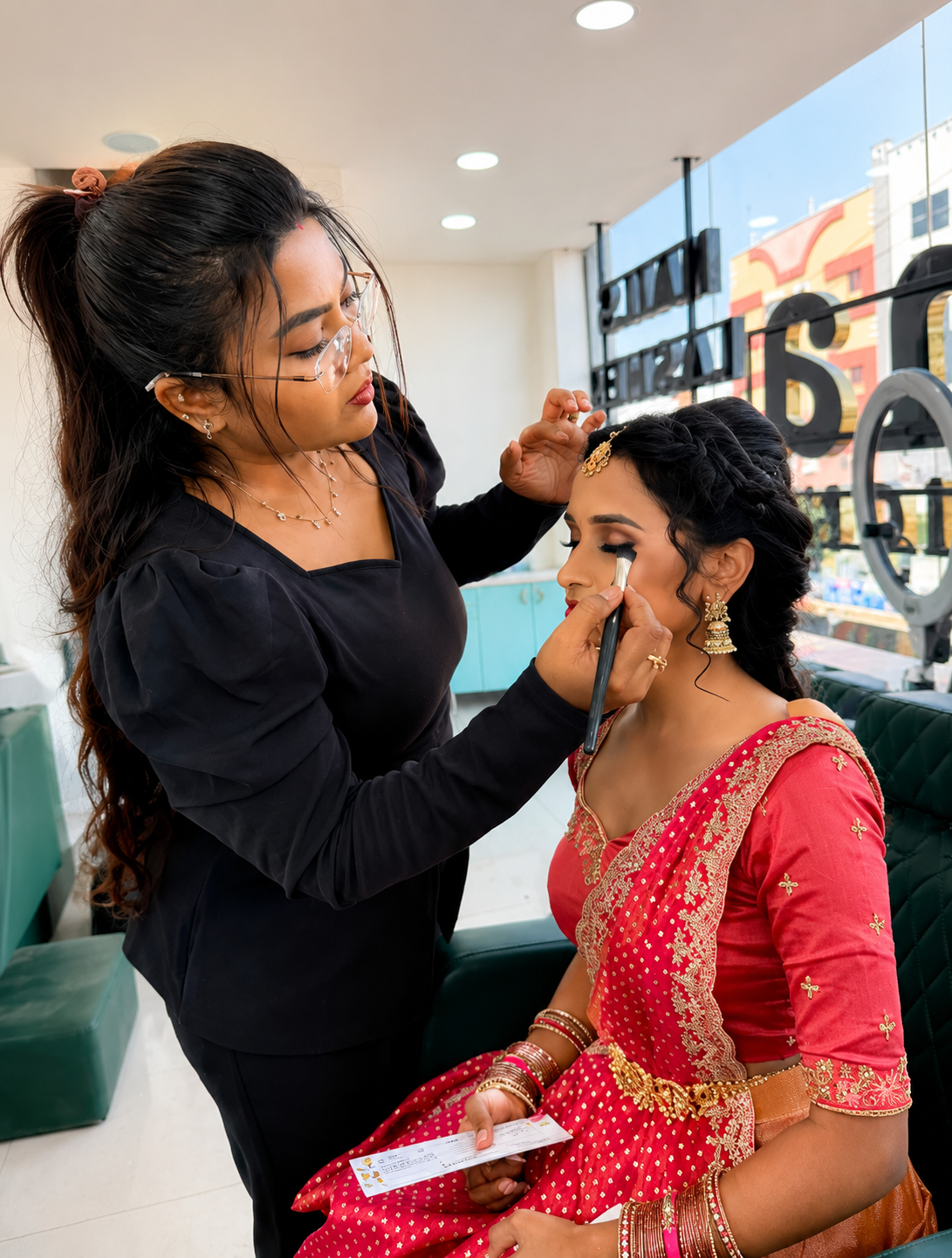 Professional makeup artist applying bridal makeup at Amrutha Salon